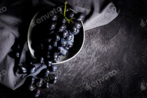Preview: top view of fresh ripe grapes and dark fabric on black
