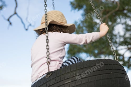 Preview: Young child with hat on home made tire swing