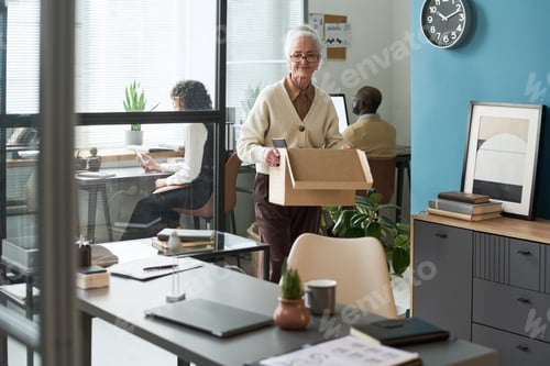 Preview: Senior Caucasian Woman Carrying Cardboard Box While Leaving Modern Office