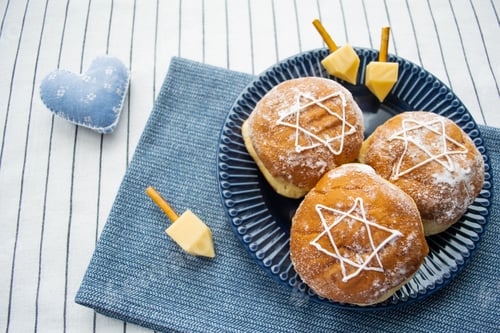 Preview: Happy Hanukkah! A traditional food: doughnuts with David star, dreidel made from cheese. Copy space