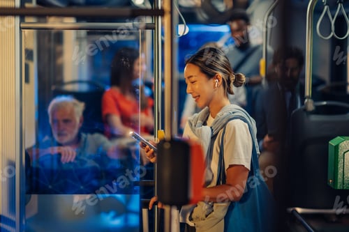 Preview: Young woman using smartphone on a bus at night