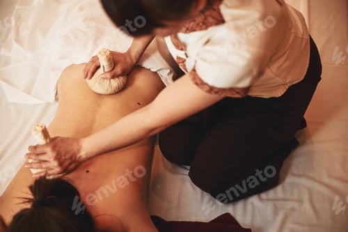 Preview: Massagist putting herbal compress balls on upper and lower back