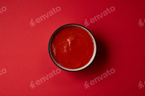 Preview: top view of tasty red tomato soup in plate on red table
