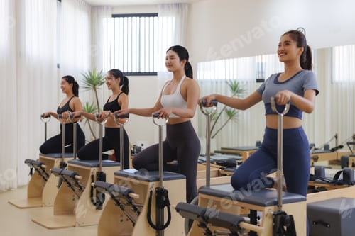 Preview: Group of young women performing pilates workout in studio