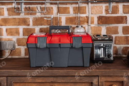 Preview: close-up shot of toolbox standing on kitchen table with toaster in front of brick wall