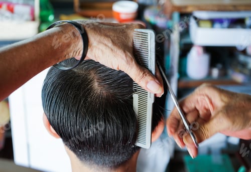 Preview: Rear view head of man having a hair cut with motion blurred hands of hairstylist