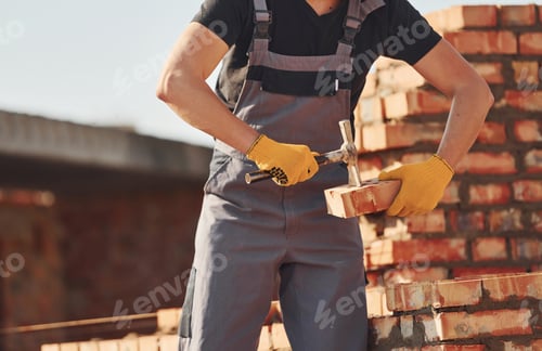 Preview: Busy with brick wall. Construction worker in uniform and safety equipment have job on building