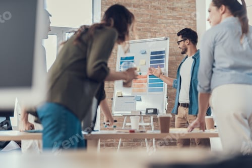 Preview: Waist Up Portrait Of Coworkers Standing At The Office Desk And Debating. Enjoyed Man Showing