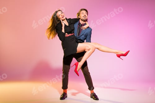 Preview: stylish boyfriend holding his excited girlfriend on arms