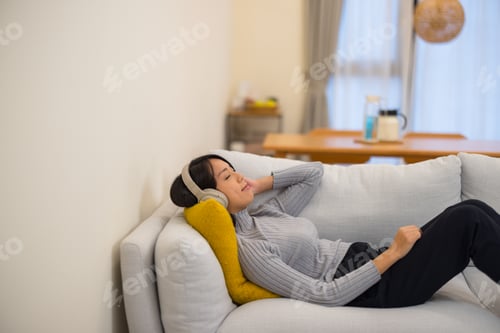 Preview: Relaxed woman listening to music while lying down