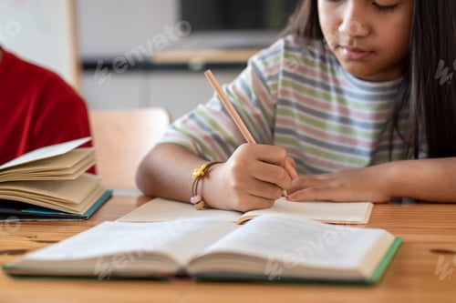 Preview: Close up of a woman hand taking notes at home.