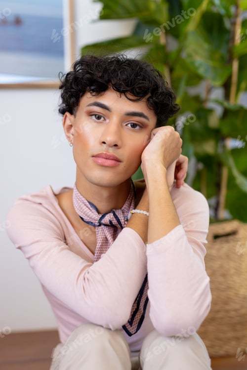 Preview: Relaxing at home, transgender transgender woman sitting and looking thoughtfully at camera