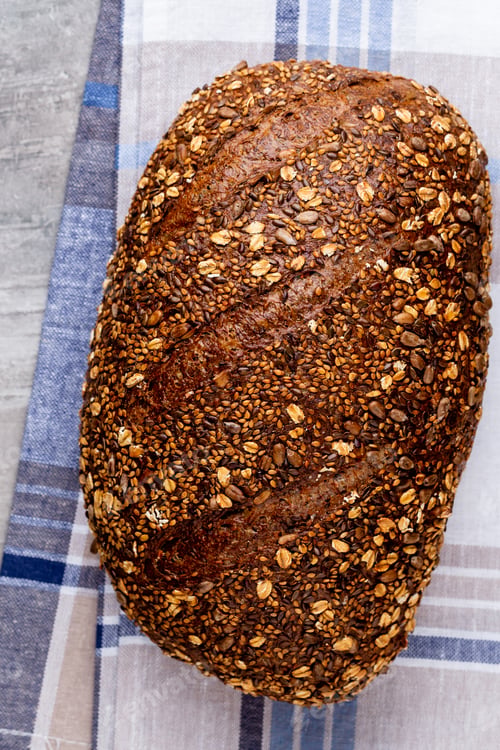 Preview: Freshly baked bread on dark gray kitchen table, top view.