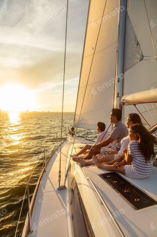Preview: Hispanic family enjoying ocean sunset from luxury yacht