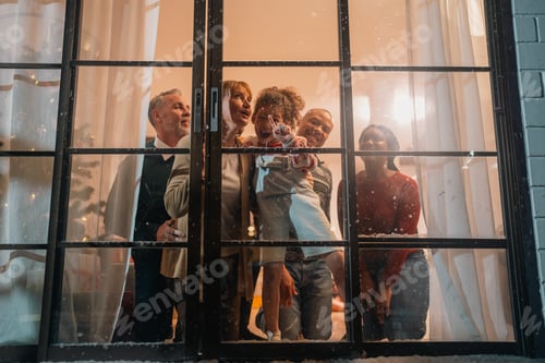 Preview: Group family looking through window at home celebration