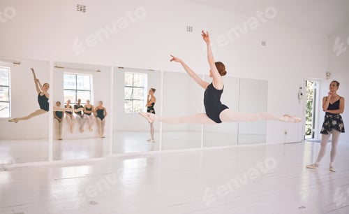 Preview: Young woman dance instructor teaching a ballet class to a group of a children in her studio. Baller