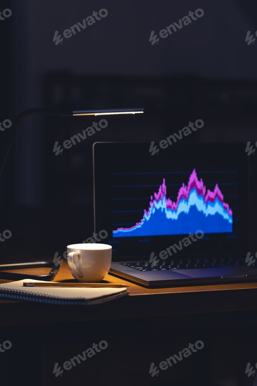 Preview: Computer in a dark room with graphs on the screen.