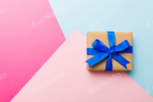 Preview: holiday paper present tied pink ribbon bow top view with copy space. Flat lay holiday background.