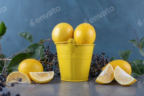 Preview: Bucket of fresh lemons and lemon slices over grey background