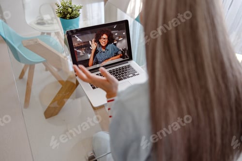 Preview: Woman using laptop for online communication with friend