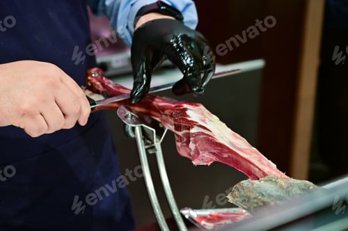 Preview: Man Slicing Spanish Jamon with Knife