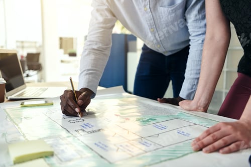 Preview: Designers studying building plans at an office desk