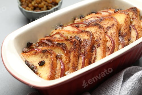 Preview: Delicious bread pudding in baking dish on light gray table, closeup
