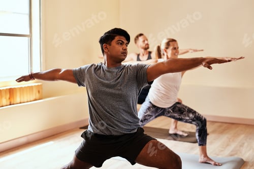 Adults Practicing Yoga Together in Bright Room