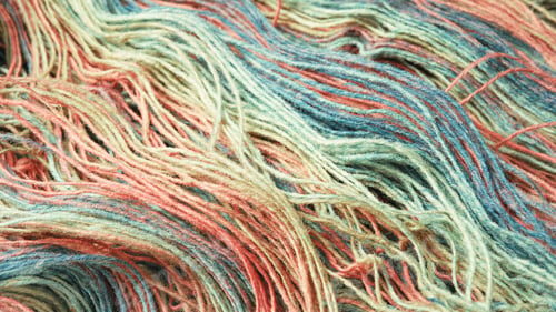 Preview: Threads from natural organic sheep wool. Unwound skein of multicolor rainbow knitting yarn.