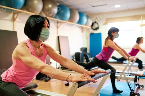 Preview: group of mature women doing excercise, Pilates and Yoga with social distancing and face mask