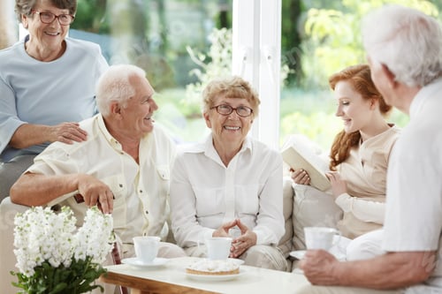 Seniors and Young Woman Enjoying Company Indoors