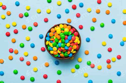 Preview: Multicolored candies in a bowl on a colored background. birthday and holiday concept.