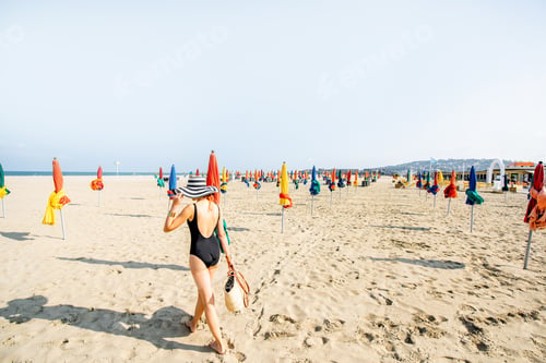 Preview: Woman on the beach with colorful umbrellas in France