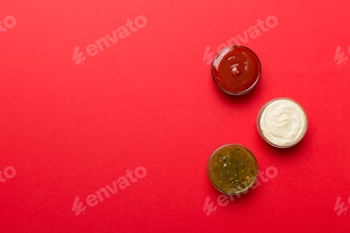 Preview: Different types of sauces in bowls on a colored Board . Top view. various sauces copy space