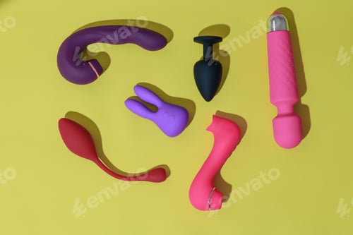 Preview: Top view of adult sex toys such as dildo, vibrator, buttplug on yellow background. Sex