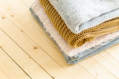 Vista previa: Stack of white cozy knitted sweaters