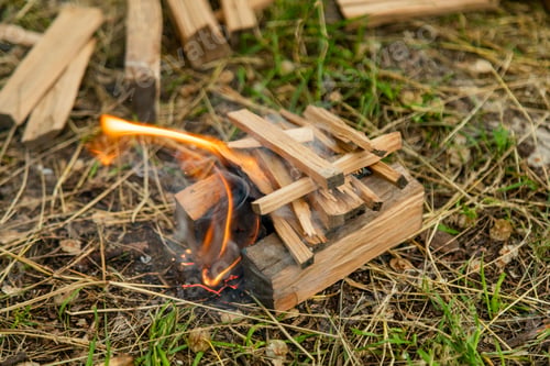 Preview: Closeup of burning wood chunks chopped as firewood lying on the ground