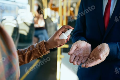 Preview: Close-up of commuters using hand sanitizer in public transport.