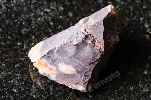Preview: sample of raw brown mookaite mineral on black