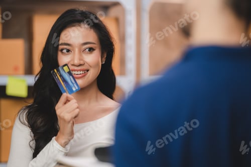 Preview: credit card wireless POS terminal payment concept, girl received a parcel from a male delivery man