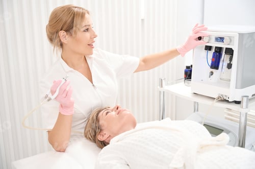 Preview: Pretty beautician adjusts CO2 laser for scar removal procedure