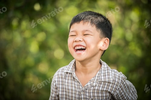 Preview: Portrait of happy little boy laughing while he play in the park.