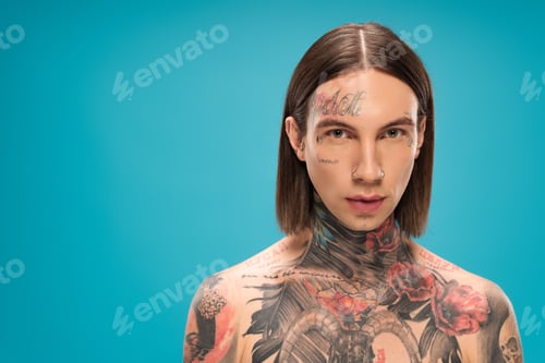 Preview: shirtless young man with tattoos looking at camera isolated on blue