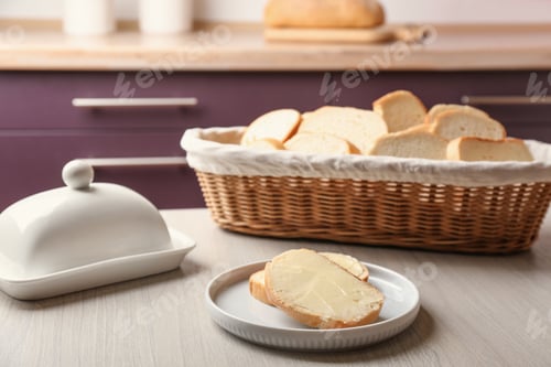Preview: Tasty fresh bread with butter on wooden table in kitchen