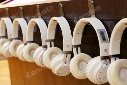 Preview: Many white earphones hang on wall closeup background
