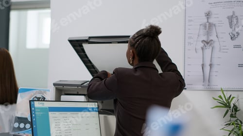 Preview: African american woman working at reception desk in health center