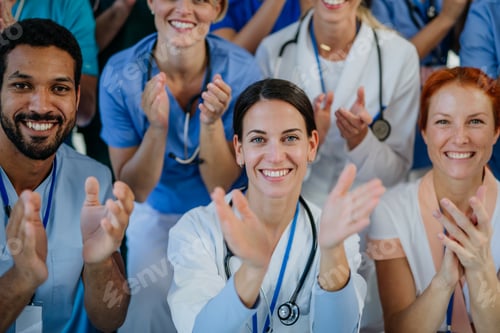 Preview: Portrait of happy doctors, nurses and other medical staff clapping in hospital.