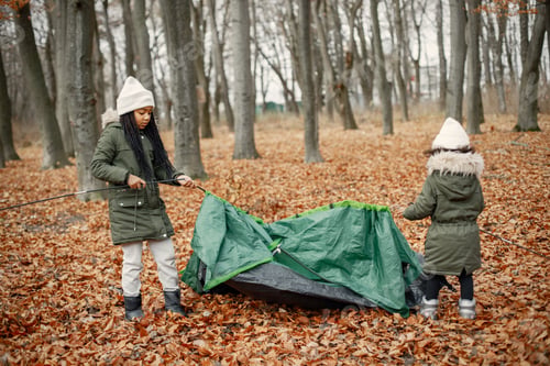 Preview: Two little black sisters in tent camping in the autumn forest