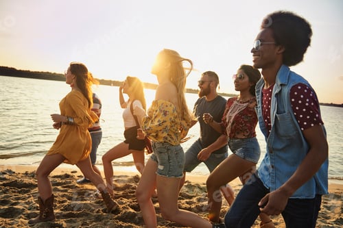 Preview: Group of fiends running on beach at sunset