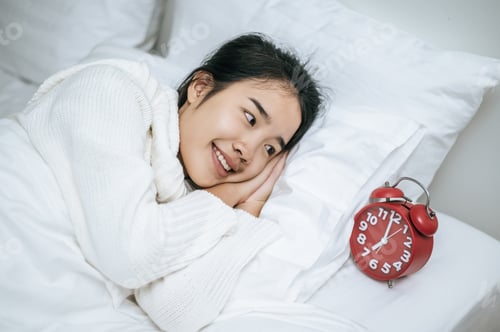 Preview: A woman wearing a white shirt lying on the bed.